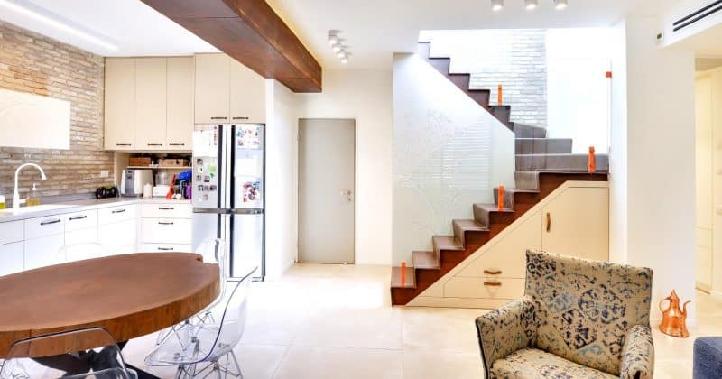 מבט על גרמי מדרגות רום ושלח מברזל מכופף על קונסטרוקציית ברזל בגמר חלוד עם מעקה זכוכית