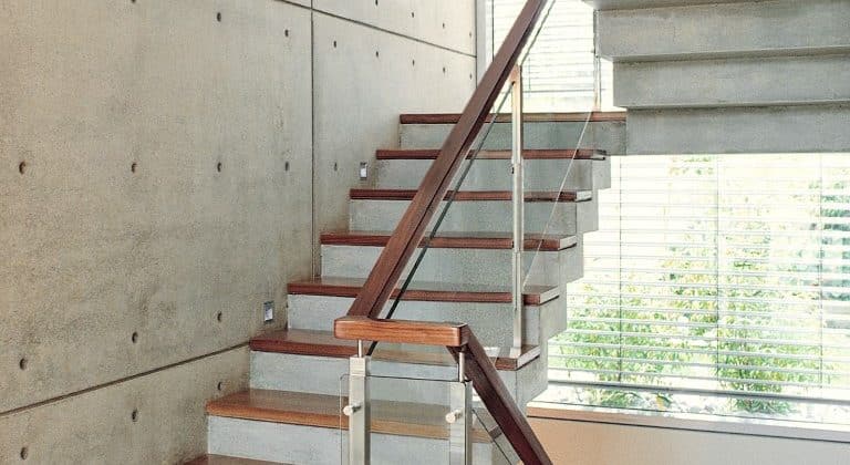 מדרגות עץ בהיר משולבות עם מעקה זכוכית וידיות עץ