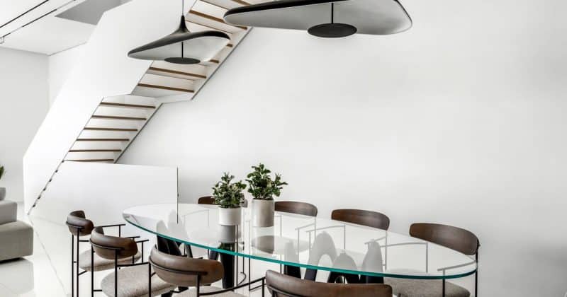 מבט צפון מלמטה על מדרגות עץ בהירות, מציג את הארכיטקטורה המודרנית והמינימליסטית של הבית.